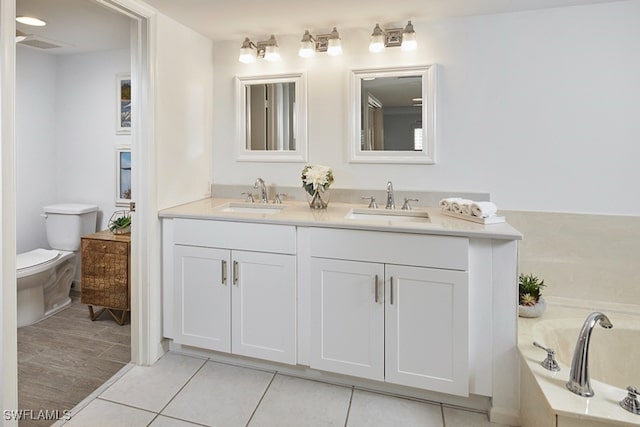 bathroom with vanity, toilet, tile patterned flooring, and a tub