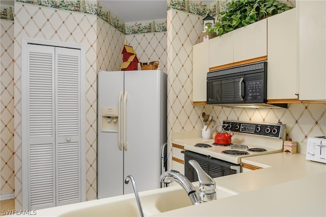 kitchen with backsplash, white cabinetry, white appliances, and sink