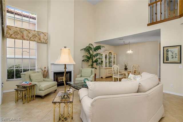 tiled living room with a towering ceiling and a chandelier