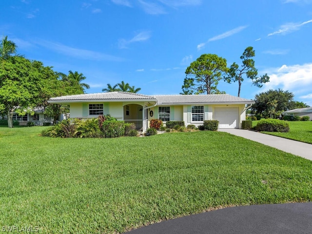 ranch-style house with a garage, a front lawn, driveway, and a tile roof