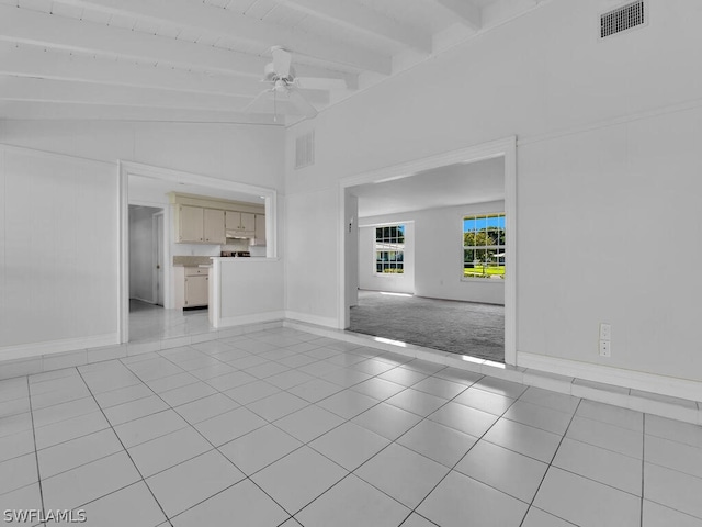 unfurnished living room with ceiling fan, light tile patterned flooring, and lofted ceiling with beams