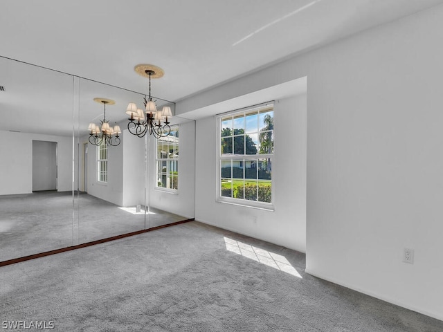 unfurnished dining area with a chandelier and carpet floors