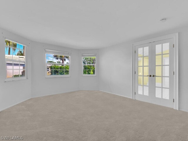 carpeted spare room with french doors