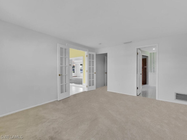 spare room with french doors, visible vents, and carpet floors