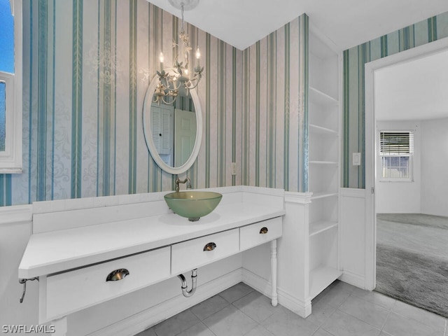 bathroom featuring tile patterned flooring, a notable chandelier, wallpapered walls, and vanity
