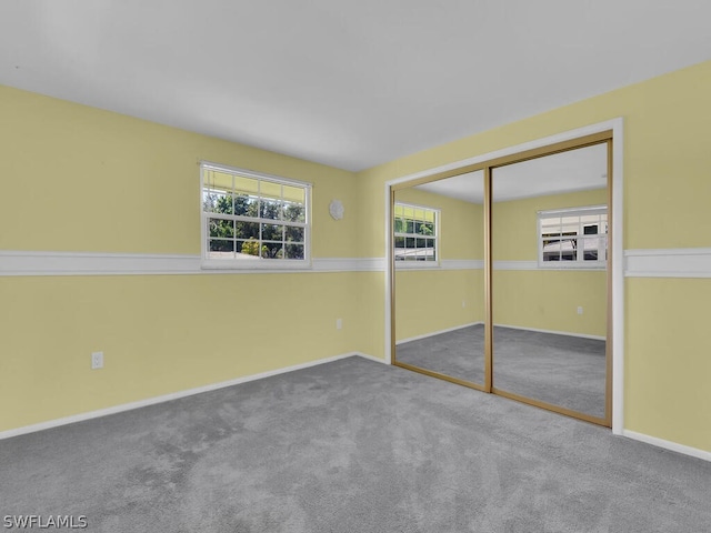 unfurnished bedroom featuring a closet, carpet flooring, and baseboards
