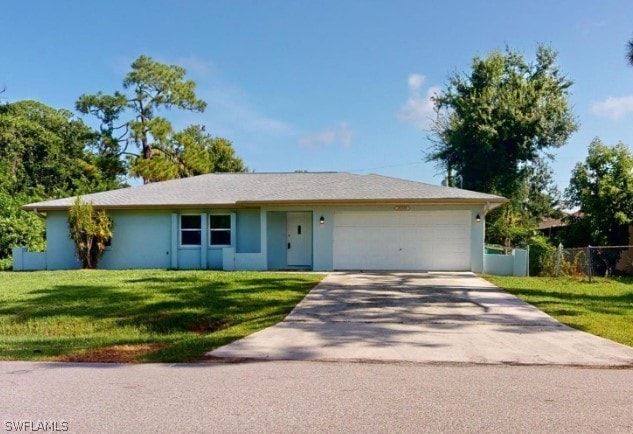 ranch-style house with a garage and a front lawn