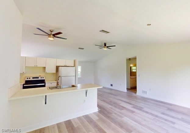 kitchen with electric range, light hardwood / wood-style flooring, white refrigerator, and ceiling fan