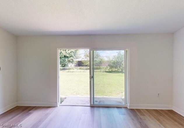 doorway to outside with wood-type flooring and a wealth of natural light