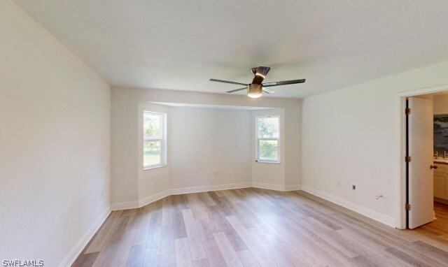 spare room featuring a wealth of natural light, ceiling fan, and light wood-type flooring