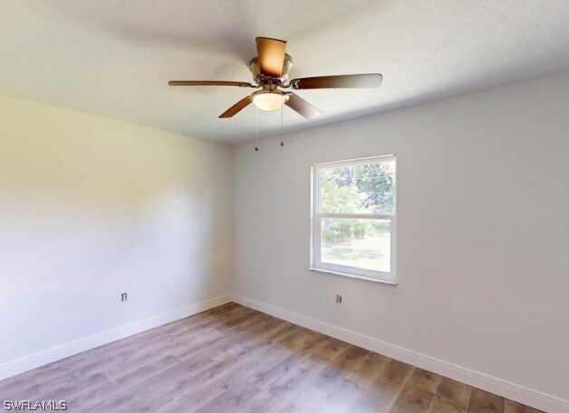 spare room with hardwood / wood-style flooring and ceiling fan