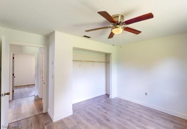 unfurnished bedroom with wood-type flooring, a closet, and ceiling fan