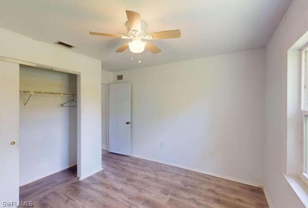 unfurnished bedroom featuring a closet, ceiling fan, and hardwood / wood-style floors