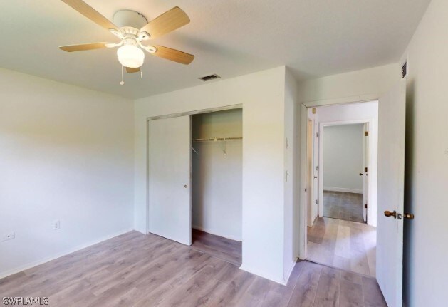 unfurnished bedroom with a closet, ceiling fan, and hardwood / wood-style floors