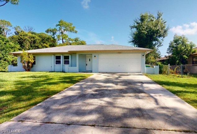 ranch-style house with a garage and a front lawn