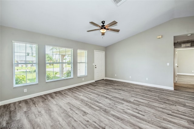 empty room featuring ceiling fan, lofted ceiling, and light wood-type flooring