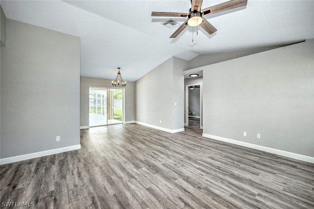 unfurnished living room with ceiling fan with notable chandelier, light hardwood / wood-style floors, and vaulted ceiling