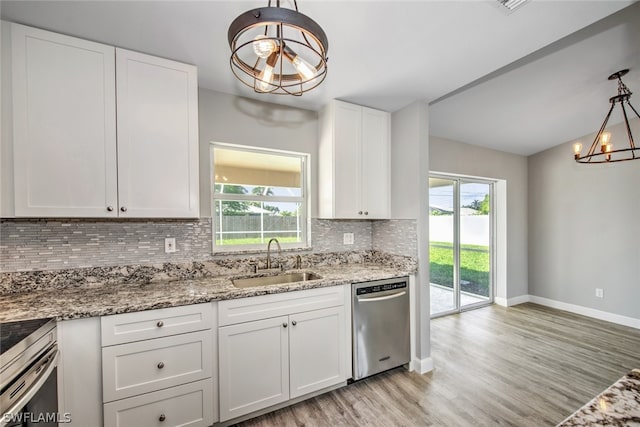 kitchen featuring white cabinetry, sink, hanging light fixtures, and appliances with stainless steel finishes