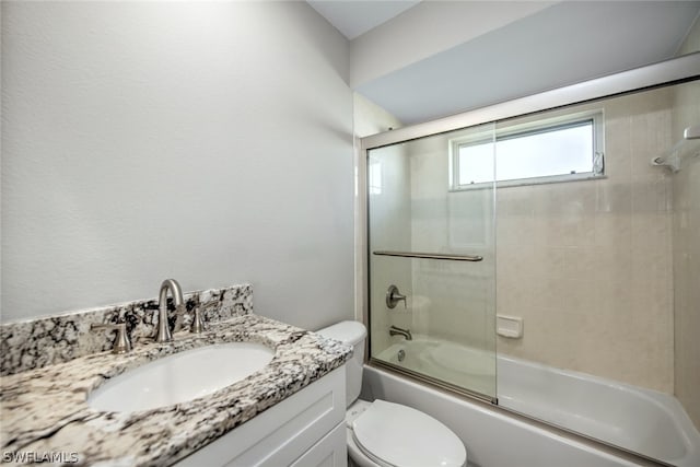 full bathroom featuring vanity, toilet, and bath / shower combo with glass door