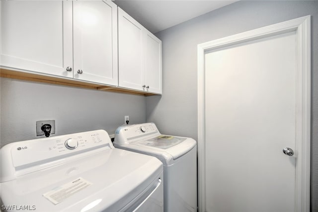 laundry room featuring cabinets and washer and dryer