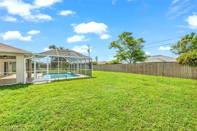 view of yard with glass enclosure and a fenced in pool