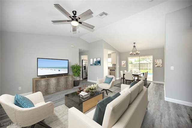 living room featuring ceiling fan with notable chandelier, light hardwood / wood-style floors, and vaulted ceiling