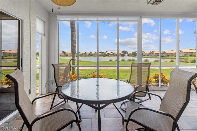 sunroom / solarium featuring a water view