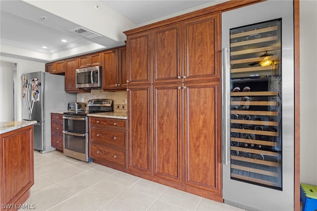 kitchen featuring tasteful backsplash, stainless steel appliances, light stone countertops, beverage cooler, and a tray ceiling