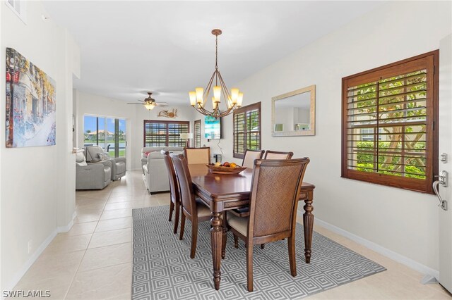 dining space with light tile patterned flooring and ceiling fan with notable chandelier