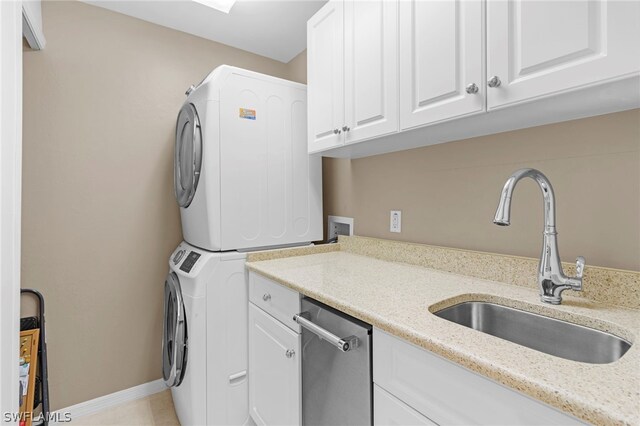 washroom with stacked washing maching and dryer, sink, cabinets, and light tile patterned floors