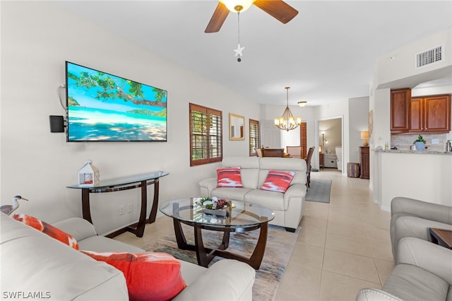 living room with light tile patterned flooring and ceiling fan with notable chandelier