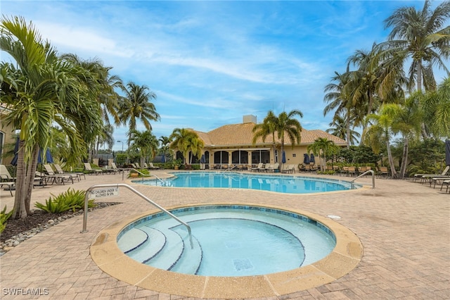 view of swimming pool with a patio area and a community hot tub