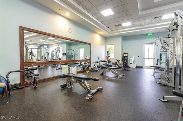 exercise room featuring a drop ceiling and a tray ceiling