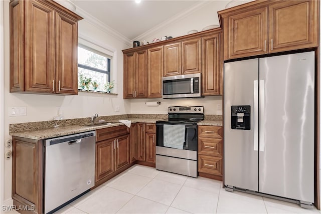 kitchen with ornamental molding, appliances with stainless steel finishes, light stone counters, light tile patterned floors, and lofted ceiling