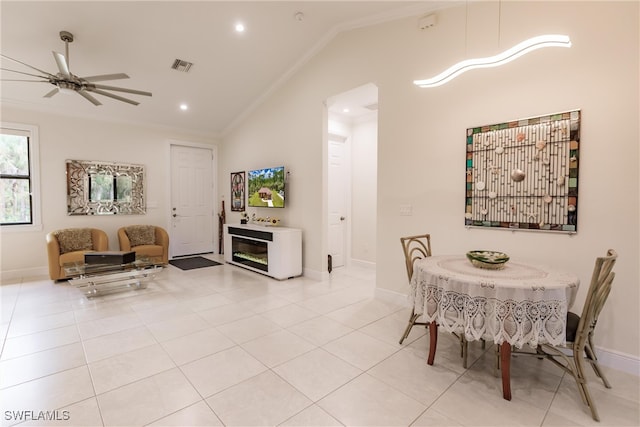 tiled dining space with ceiling fan, lofted ceiling, and ornamental molding