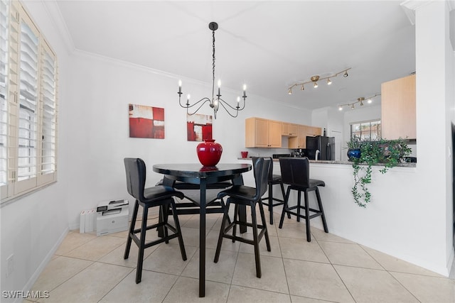 tiled dining space featuring a notable chandelier and ornamental molding