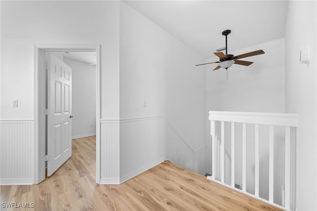 hallway featuring light wood-type flooring and vaulted ceiling