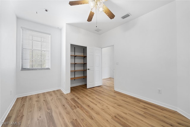 unfurnished bedroom with a closet, light hardwood / wood-style floors, and ceiling fan