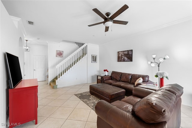 living room with light tile patterned floors, ornamental molding, and ceiling fan