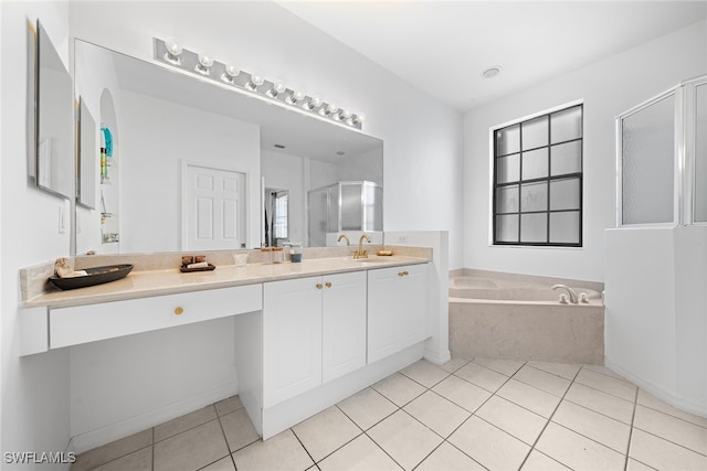 bathroom with a healthy amount of sunlight, tile patterned floors, independent shower and bath, and vanity