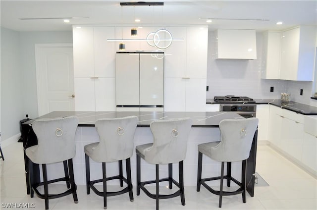 kitchen with a breakfast bar area, white cabinets, decorative backsplash, a center island, and stainless steel appliances