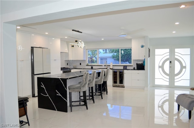 kitchen with refrigerator, light tile patterned flooring, hanging light fixtures, and wine cooler