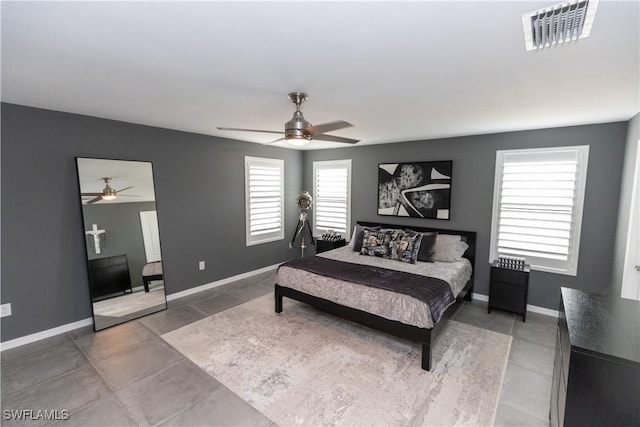 bedroom with tile patterned flooring, visible vents, ceiling fan, and baseboards