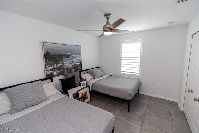 tiled bedroom featuring ceiling fan and baseboards