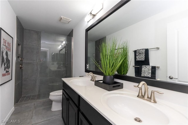 full bath featuring toilet, tile patterned flooring, double vanity, and a sink