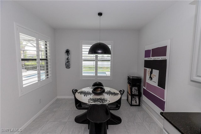 dining space featuring light tile patterned flooring and baseboards