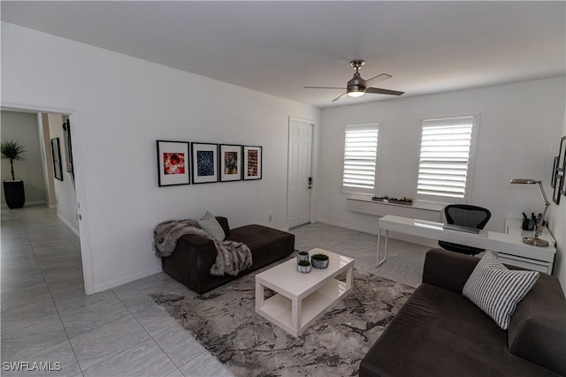 living area with ceiling fan, light tile patterned floors, and baseboards