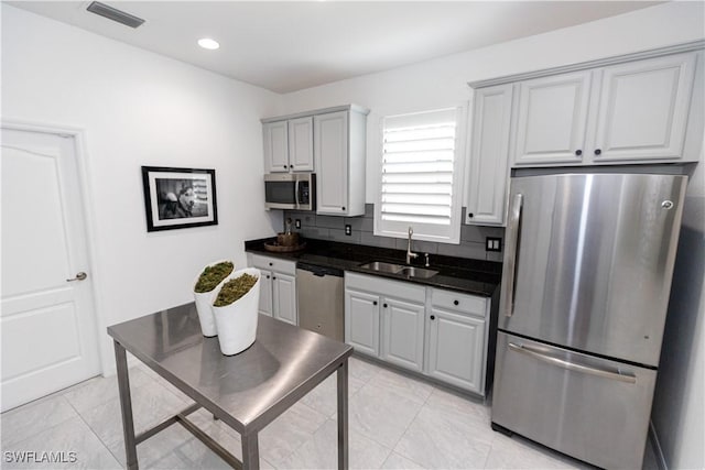 kitchen with gray cabinets, appliances with stainless steel finishes, sink, backsplash, and light tile patterned floors