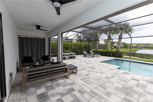 view of swimming pool with a patio, an outdoor hangout area, ceiling fan, glass enclosure, and a water view