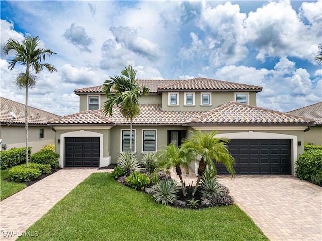 mediterranean / spanish-style home featuring a garage and a front yard